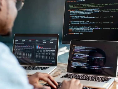 Hombre-programando-en-computadora-y-dos-laptop banner